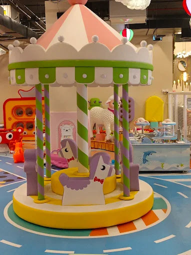 Colorful indoor carousel with horse-shaped seats and striped poles in a vibrant children's play area