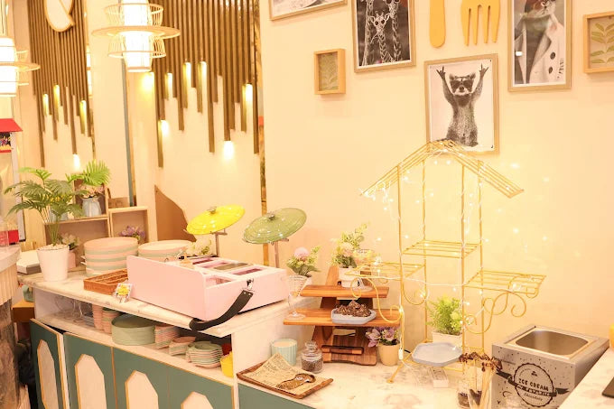 Cozy indoor dessert counter with pastel decor, plants, and elegant lighting in a children’s play café setting