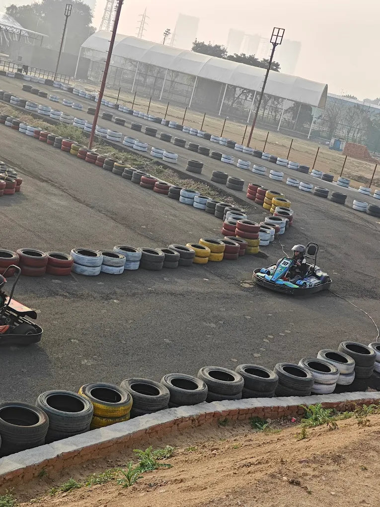 A go-kart race track with a person driving a go-kart.