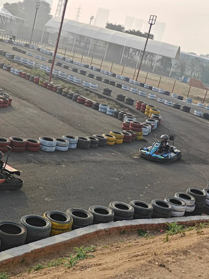 A go-kart race track with a person driving a go-kart.