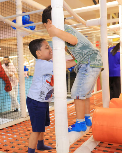 Two young boys interacting and climbing on white padded bars in Walk to Wonderland Indoor Play Area Chhatarpur
