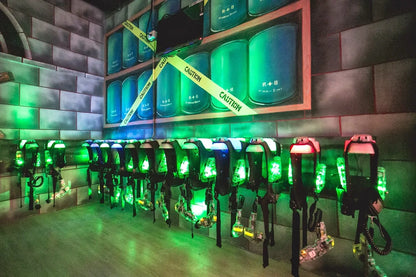 Laser tag vests and phasers are displayed in a dimly lit arena with green lighting.