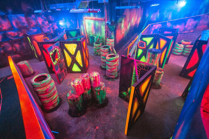 A neon-lit laser tag arena with obstacles and glowing walls, ready for players.