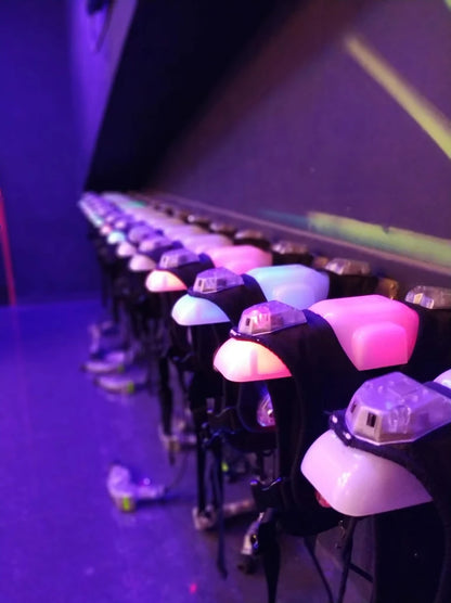 Row of illuminated laser tag vests in a dimly lit arena.