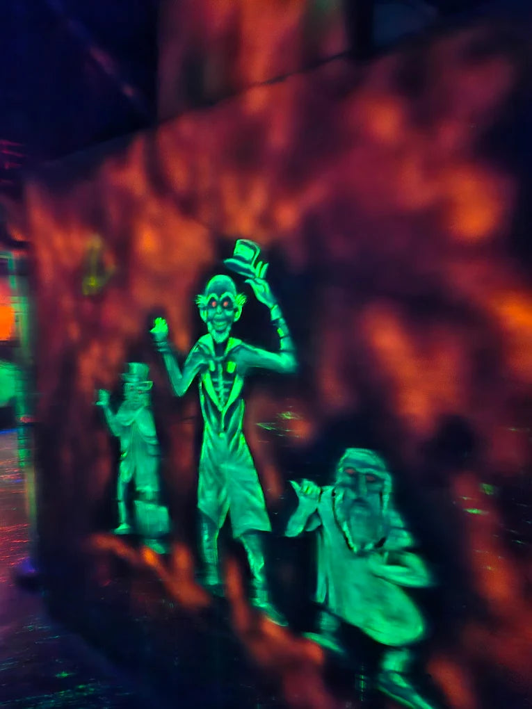 Neon green figures in a dark, spooky setting, possibly a haunted attraction.