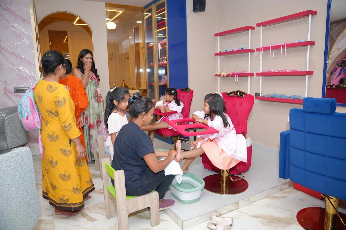 Young girls enjoy pedicures at a spa, with one girl receiving a foot massage while others wait.