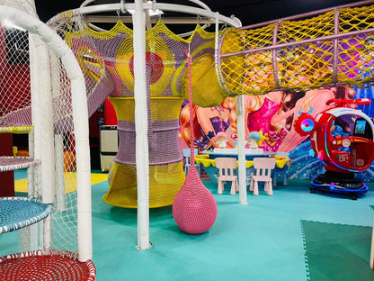 A colorful indoor playground with nets, slides, and a toy helicopter, designed for young children.