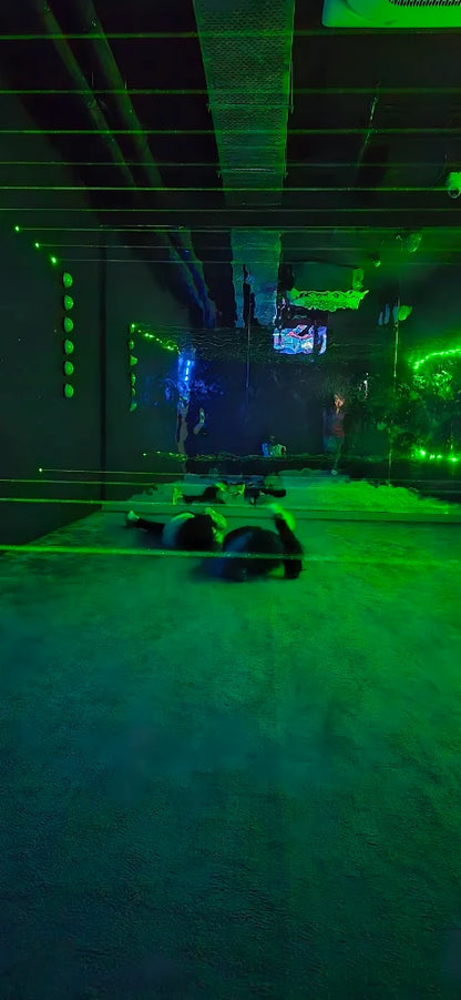 People lying on a floor illuminated by green lights.