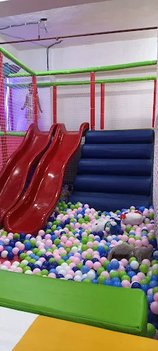 A ball pit with slides and soft play structures, likely for young children.