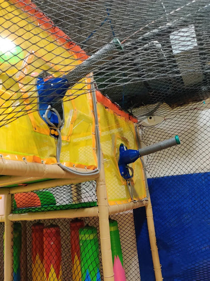 A children's indoor playground with soft play structures and netting.