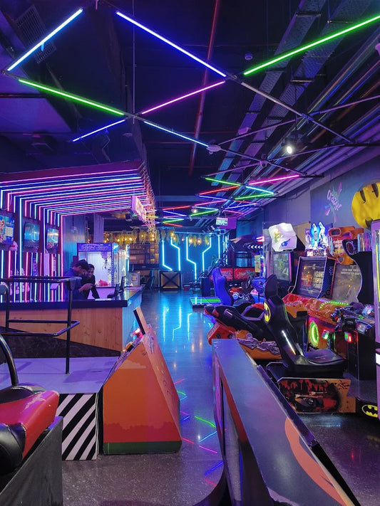Arcade with neon lights and racing games.