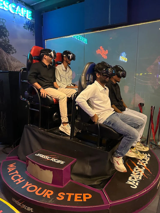 Young adults wearing VR headsets sit in a Jurassic Escape ride.