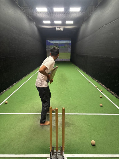 Person playing indoor cricket with a virtual display in the background