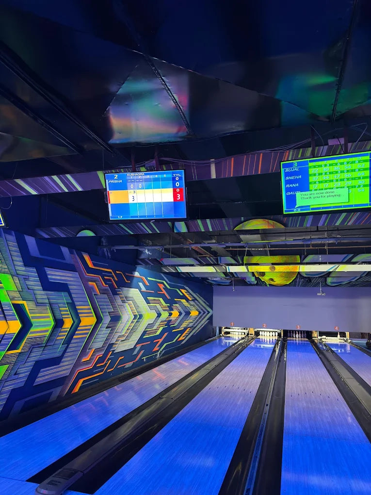 Bowling alley with lanes and digital scoreboards in a modern indoor setting.