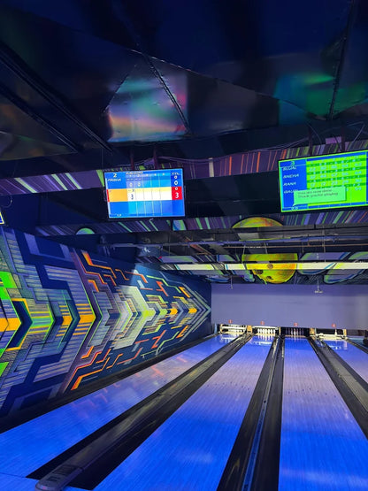 Bowling alley with lanes and digital scoreboards in a modern indoor setting.