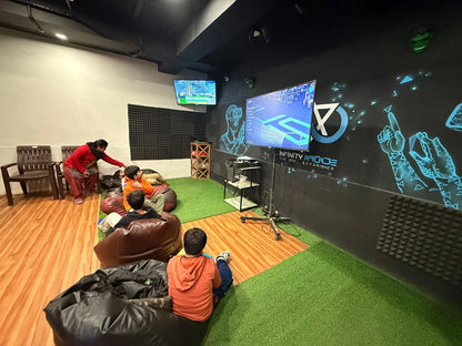 Children play video games in a VR arcade while a woman watches.