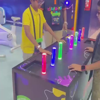 Children engage in interactive games and activities at Curious Kids, an edutainment center. The vibrant environment features various play zones, including a race track, trampoline area, and ball pit. The atmosphere is lively and fun, with kids learning real-life skills and earning currency.