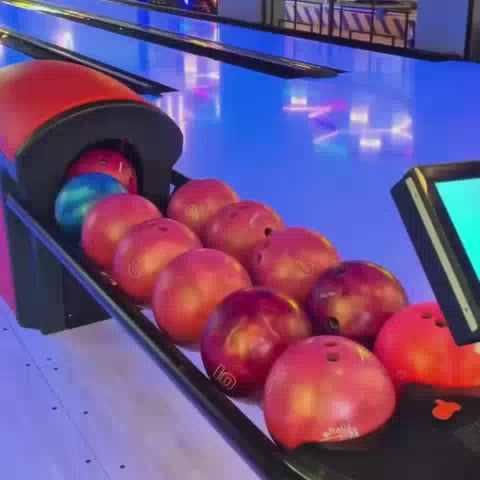 A family enjoys a fun-filled day at an arcade and bowling alley. Children and adults alike engage in various activities like bowling, playing arcade games, and celebrating a birthday. The vibrant, neon-lit environment creates a lively and festive atmosphere.