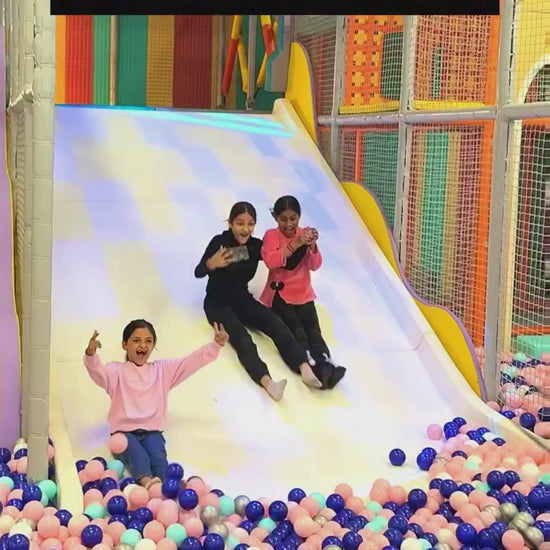 Children and adults enjoy a vibrant indoor thrill zone with ball pits, arcade games, bowling, and virtual reality experiences. The colorful, energetic environment is filled with laughter and excitement, featuring various attractions for all ages.