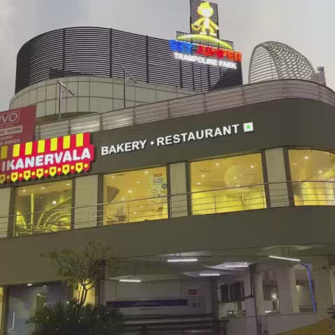 A trampoline park with colorful trampolines, foam pits, and a rock-climbing wall offers fun for all ages. The vibrant, energetic atmosphere is perfect for active play and exciting adventures.