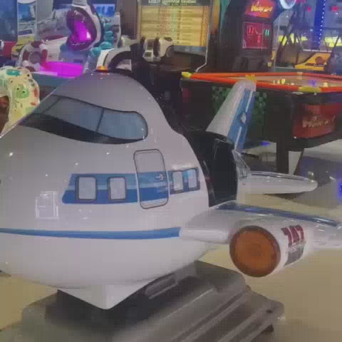 This video showcases a vibrant arcade filled with colorful kiddie rides like an airplane, octopus, train, giraffe, and horse. The setting is a lively entertainment center, likely for young children, with various arcade games and attractions visible in the background. The atmosphere appears energetic and fun, with flashing lights and engaging rides creating a playful environment.