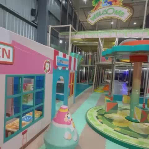A vibrant indoor playground with multi-level structures, ball pits, slides, and go-karts provides fun for children of various ages. The colorful and engaging environment features playful decorations like dinosaurs and a mini-supermarket, creating a lively and exciting atmosphere for active play.
