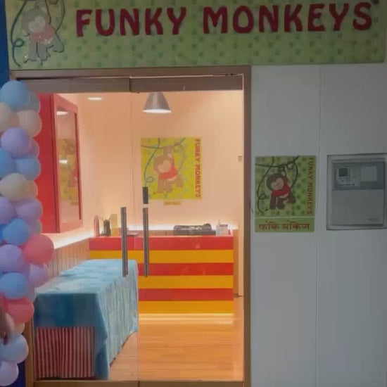 A young child enjoys a vibrant indoor playground with colorful slides, tunnels, and interactive games. The atmosphere is lively and fun, perfect for toddlers and young children to explore and play.