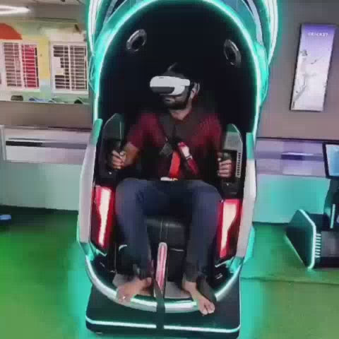 A group of people, including children and adults, enjoy a variety of arcade games and attractions. The setting is a vibrant indoor entertainment center with colorful lights and exciting rides like a VR simulator, air hockey, a hammer game, bowling, and a soft play area with a ball pit and slides. The atmosphere is lively and fun, with everyone engaged in playful activities.