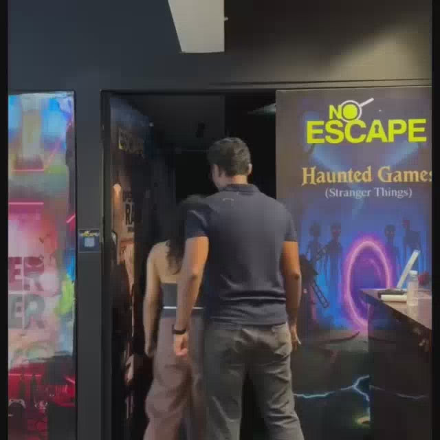 A group of young adults participates in a dimly lit escape room, navigating a spooky, themed environment with various props and puzzles. The atmosphere is a mix of excitement and suspense as they search for clues and work together to solve challenges.