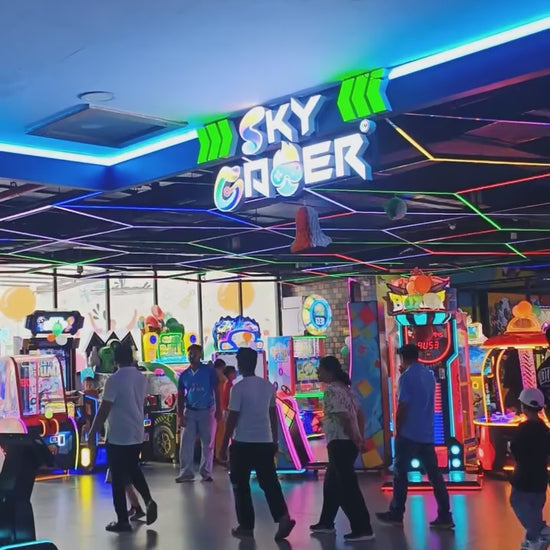 Kids and adults enjoying an indoor gaming zone with arcade machines, racing games and interactive play setups, offering fun and engaging entertainment activities.