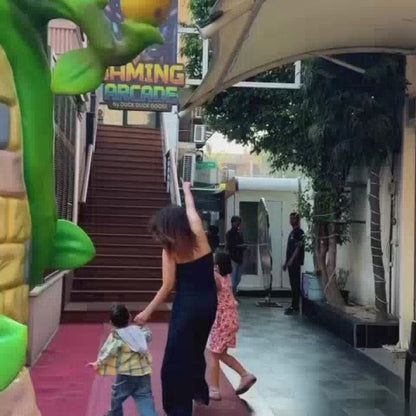 A vibrant arcade buzzes with excitement as children and adults engage with various games. From racing simulators and VR experiences to claw machines and soft play areas, the atmosphere is filled with fun and laughter. Families enjoy a day of entertainment, with younger kids delighting in slides and older ones tackling challenging arcade games.