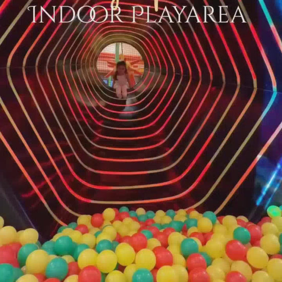 A vibrant indoor play area filled with colorful balls, slides, and climbing structures. Children of various ages enjoy the exciting activities, creating a lively and joyful atmosphere. The play area features a ball pit, a tube slide, and interactive games, offering endless fun for young adventurers.