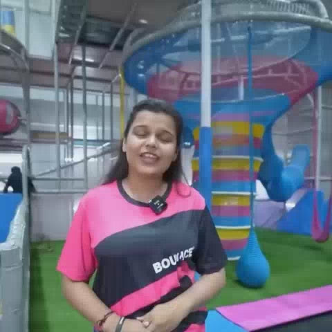 A vibrant indoor adventure park buzzes with energy as children of various ages navigate colorful climbing walls, trampolines, and obstacle courses. The atmosphere is lively and exciting, with bright equipment and playful designs creating a fun-filled environment for active exploration.