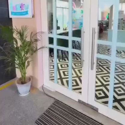 A playful indoor playground with a pink and white theme, featuring a large inflatable bunny mascot, a ball pit, and a carousel with horse toys. Children of various ages are seen enjoying the attractions, with some engaging in crafts at a table. The atmosphere is festive and vibrant, with colorful decorations and a sense of joyful activity.
