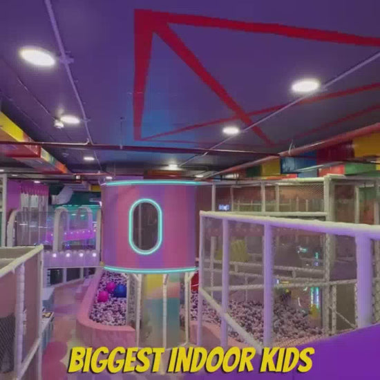 A vibrant indoor play area, filled with colorful slides, ball pits, and climbing structures, offers endless fun for children of various ages. The atmosphere is energetic and exciting, with kids actively engaged in playful activities like sliding, swinging, and exploring. Notable features include a large ball pit, a tube slide with neon lights, and a trampoline area, creating a stimulating environment for active play.