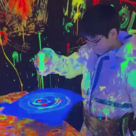 Kids, Teens and adults enjoying a neon paint zone with glow-in-the-dark colors, offering a fun, creative, and immersive indoor entertainment experience.