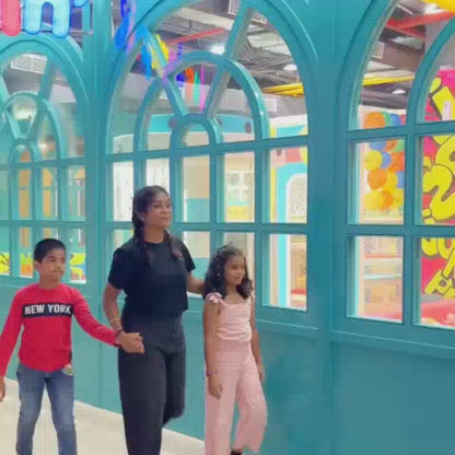 A vibrant indoor play area with colorful slides, ball pits, and climbing walls provides endless fun for young children. The atmosphere is lively and energetic, with kids of various ages actively engaged in play. The setting is designed to be visually stimulating and safe for children's activities.