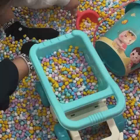 Children of various ages enjoy a vibrant indoor play area filled with ball pits, a carousel, interactive screens, and climbing structures. The atmosphere is lively and playful, with bright colors and engaging equipment designed for fun and exploration.