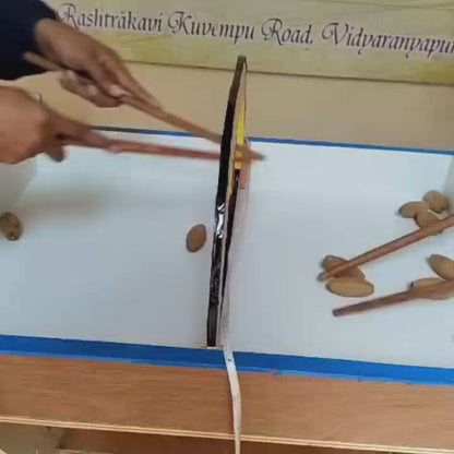 Children engage in various games at a Montessori school. They use chopsticks to pick up almonds, play a ring toss game, and practice archery. The atmosphere is playful and educational, with colorful equipment and a bright, open environment.