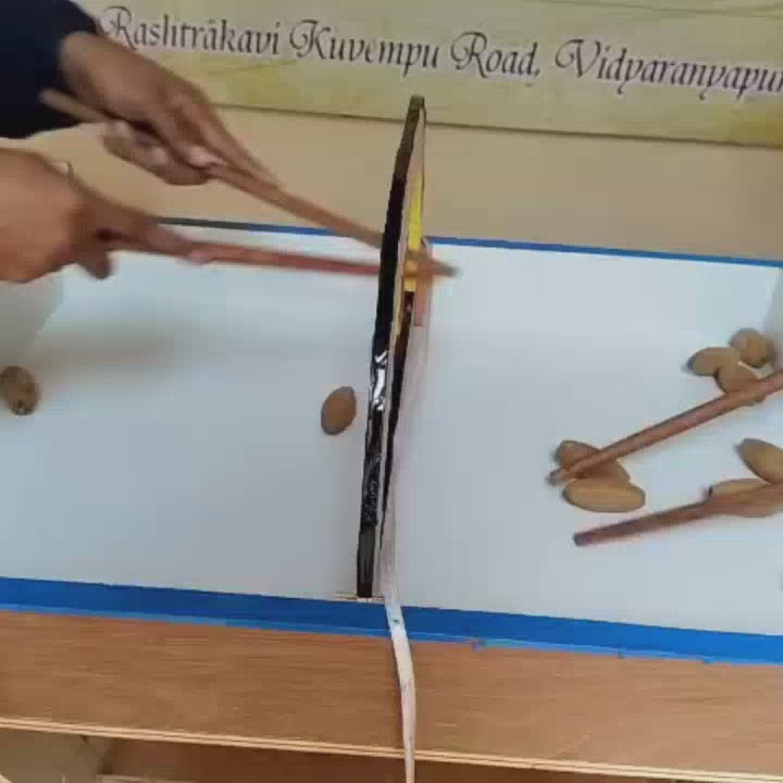 Children engage in various games at a Montessori school. They use chopsticks to pick up almonds, play a ring toss game, and practice archery. The atmosphere is playful and educational, with colorful equipment and a bright, open environment.