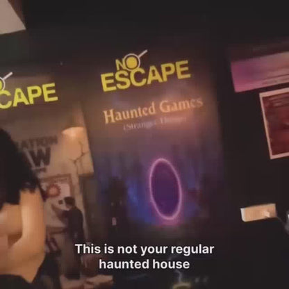 A group of young adults participates in a "Haunted Games" escape room experience. The dimly lit environment features spooky decorations, puzzles, and sound effects, creating a thrilling and immersive atmosphere. Participants use a walkie-talkie to communicate with the game master as they solve mysteries within the hour-long challenge.