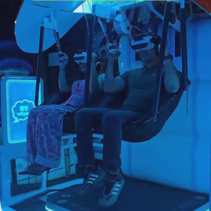 A group of young adults enjoys a vibrant arcade, engaging in various games like VR paragliding, air hockey, and bowling. The setting is a lively entertainment center with neon lights, colorful decorations, and a variety of arcade machines. The atmosphere is energetic and fun, with people of different ages actively participating in the games.
