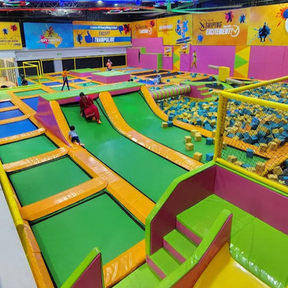 Colorful indoor playground with slides, foam pit and trampoline areas