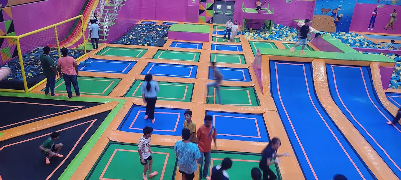 Children playing in a colorful indoor playground with various activities and slides.